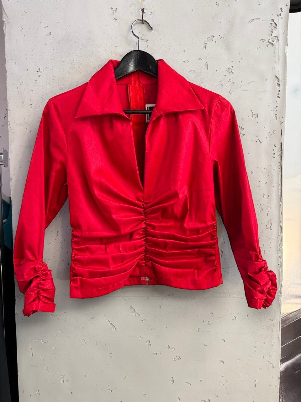 BERLIN VINTAGE CORNER red long sleeve blouse with a pointed collar and ruched front detailing on a hanger.