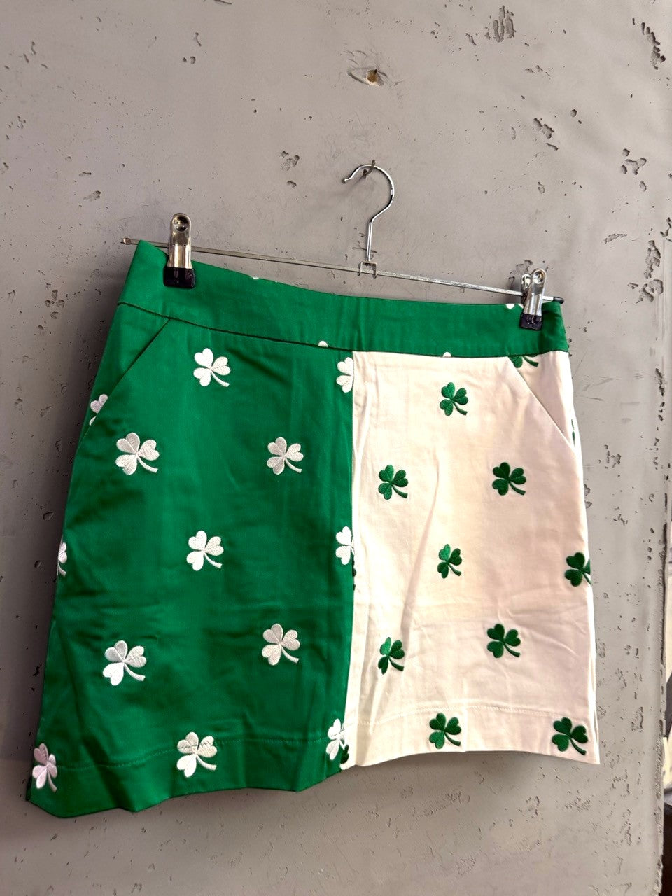 BERLIN VINTAGE CORNER green and white color-blocked golf mini skirt with embroidered shamrock pattern and pockets.