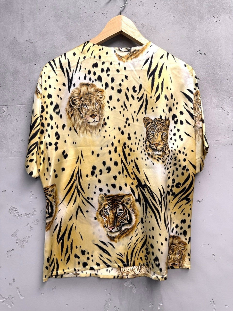 BERLIN VINTAGE CORNER silk animal print blouse with tigers, lions, and leopards. Features gold-tone shoulder buttons.