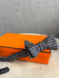 BERLIN VINTAGE CORNER black, white, and brown silk bow tie with all-over H pattern.