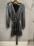 BERLIN VINTAGE CORNER silver sequin wrap dress with V-neck, long sleeves, tie waist, and ruffled hem.
