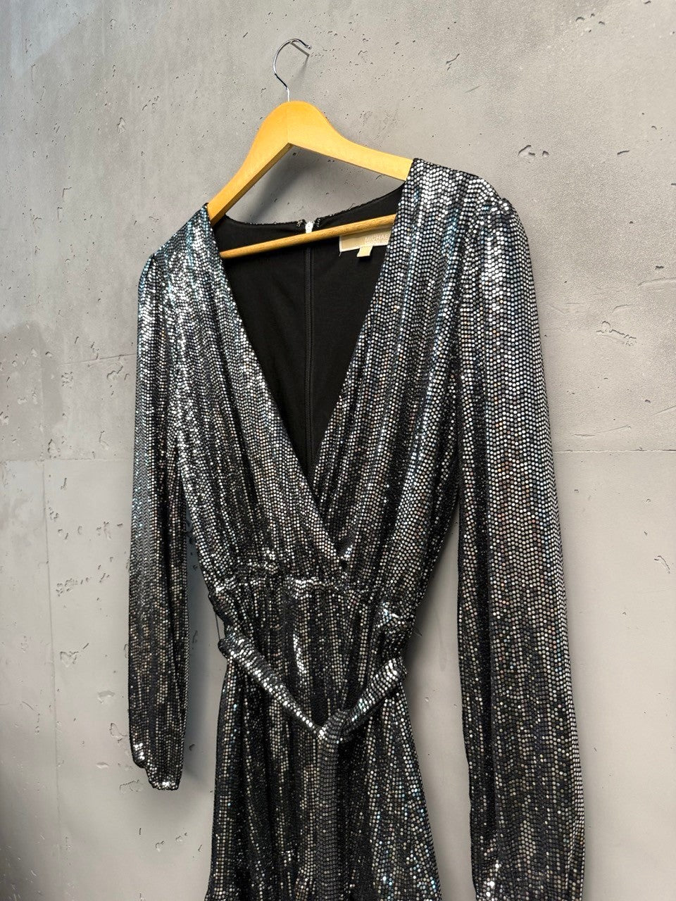 BERLIN VINTAGE CORNER silver sequin wrap dress with V-neckline, long sleeves, tie waist, and ruffled hem.