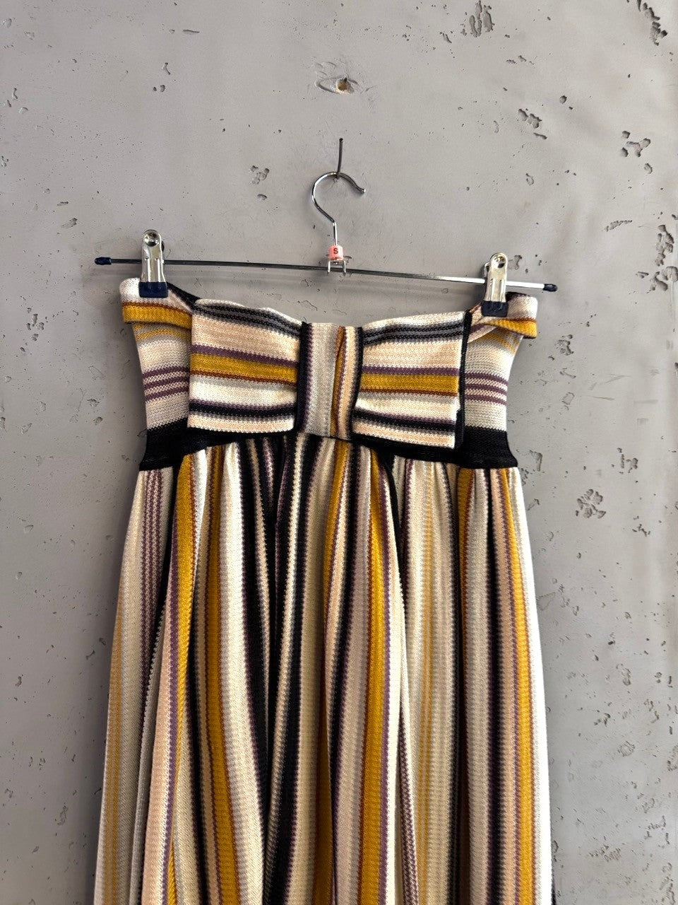 BERLIN VINTAGE CORNER strapless midi dress with multi-colored vertical stripes in cream, mustard, purple, and black knit fabric.