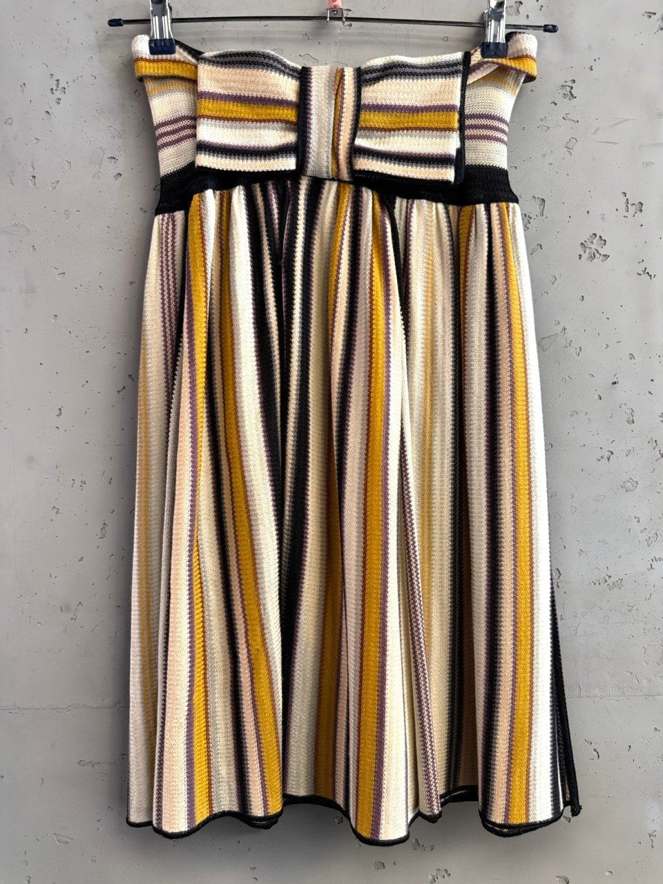 BERLIN VINTAGE CORNER strapless midi dress with multi-colored vertical stripes in cream, mustard, purple, and black knit fabric.