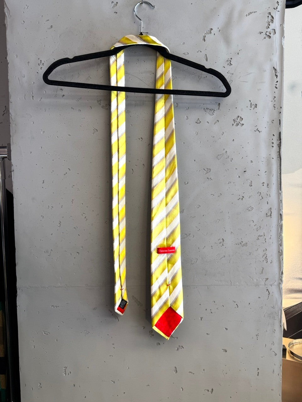 BERLIN VINTAGE CORNER yellow, white, and grey striped silk necktie with a red tip.
