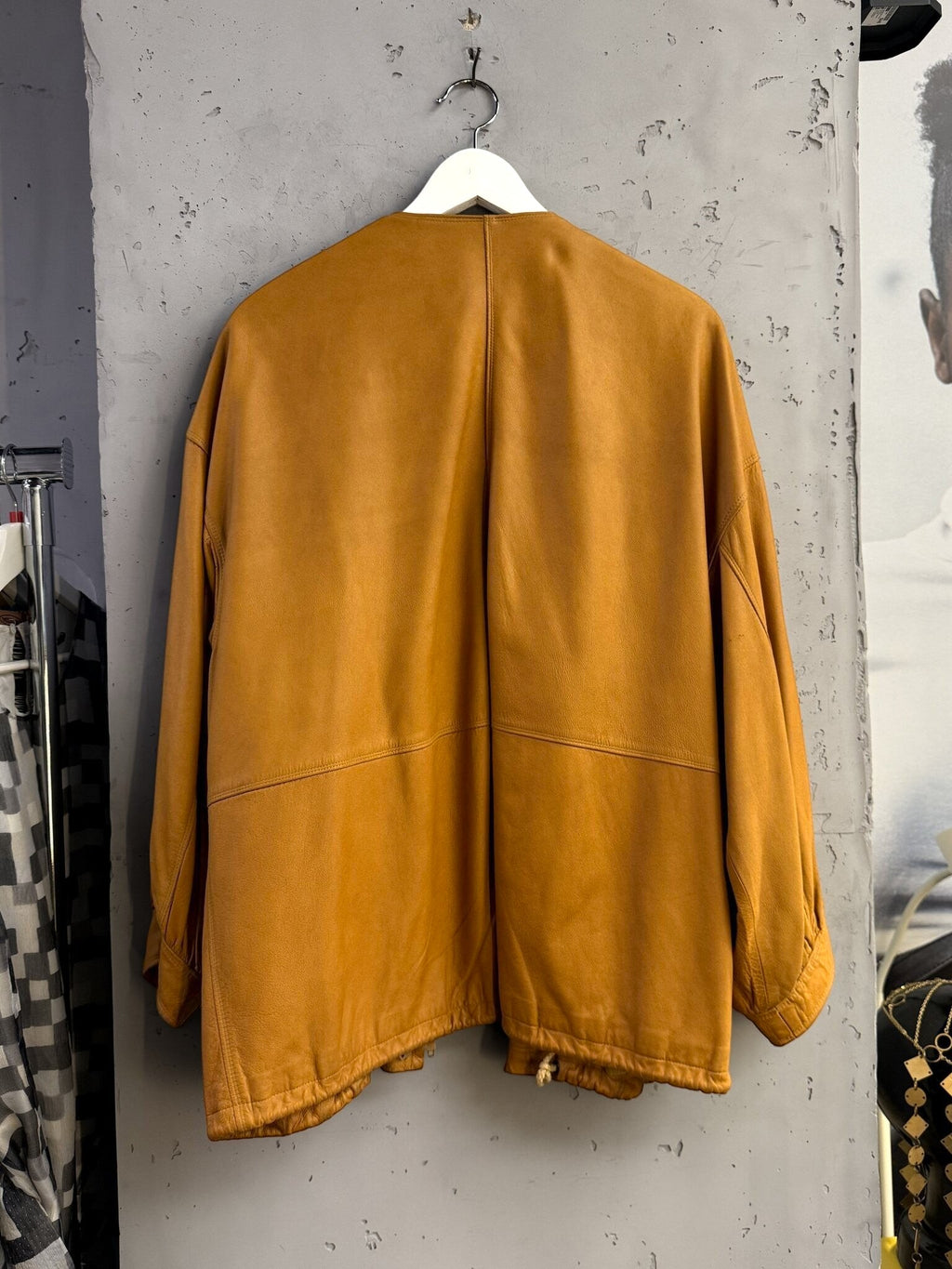 Back view of a BERLIN VINTAGE CORNER Jil Sander+ tan leather jacket with a collarless design and relaxed fit.