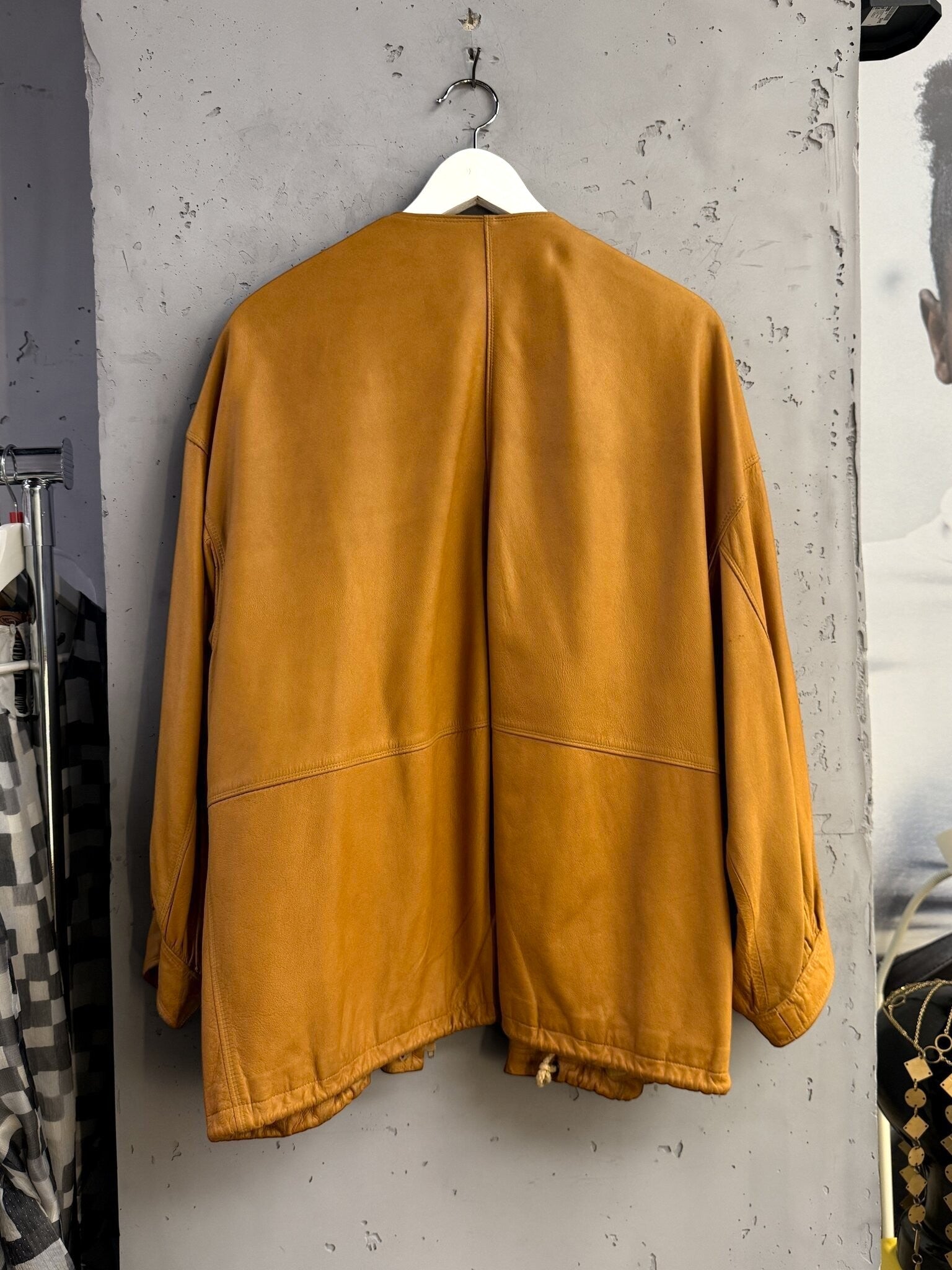 Back view of a BERLIN VINTAGE CORNER Jil Sander+ tan leather jacket with a collarless design and relaxed fit.