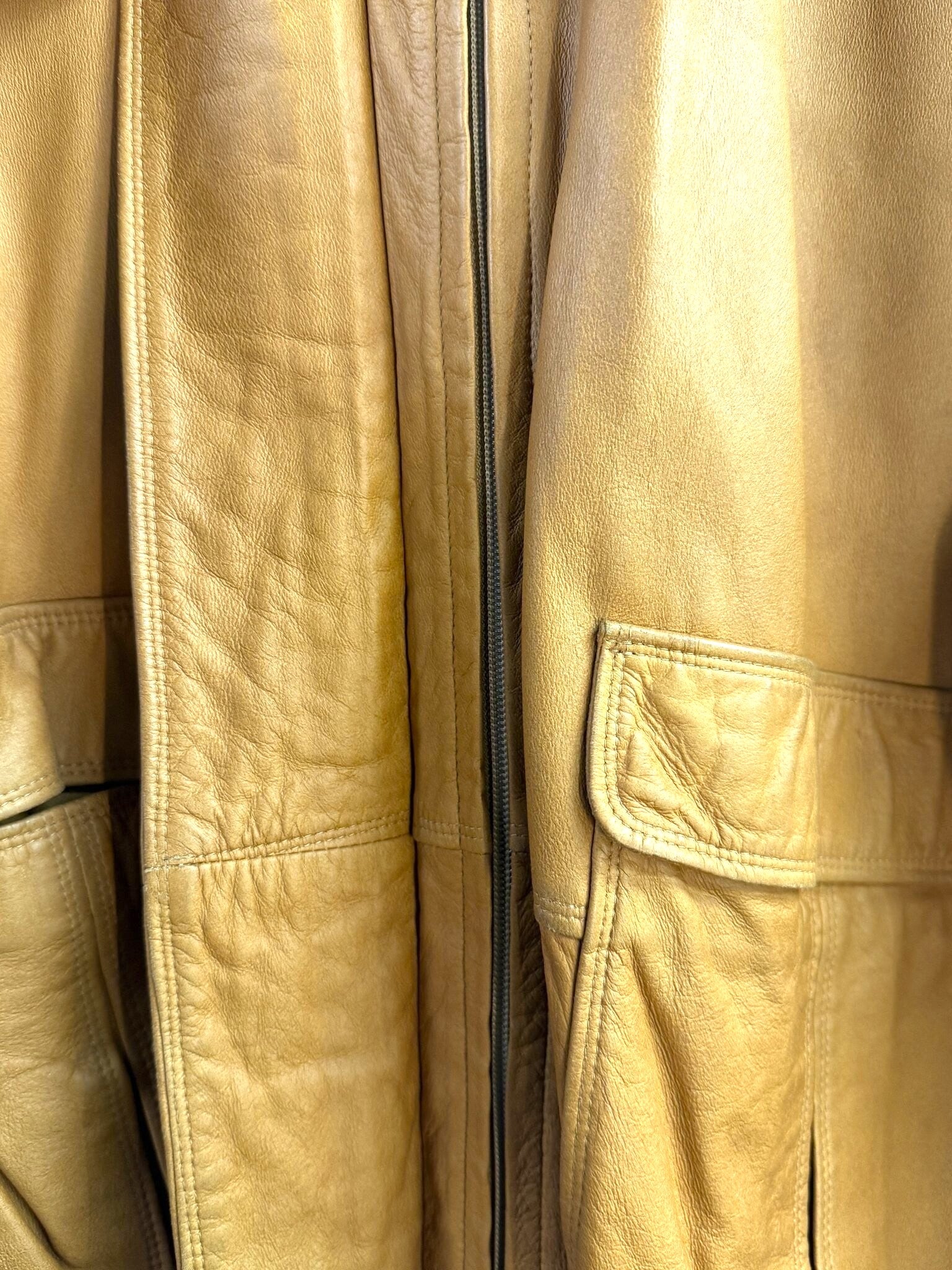 Close-up of a BERLIN VINTAGE CORNER Jil Sander+ tan leather jacket featuring soft texture and structured front pockets