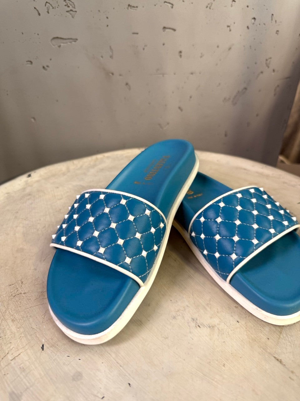 BERLIN VINTAGE CORNER teal slide sandals with white trim and quilted studded straps.