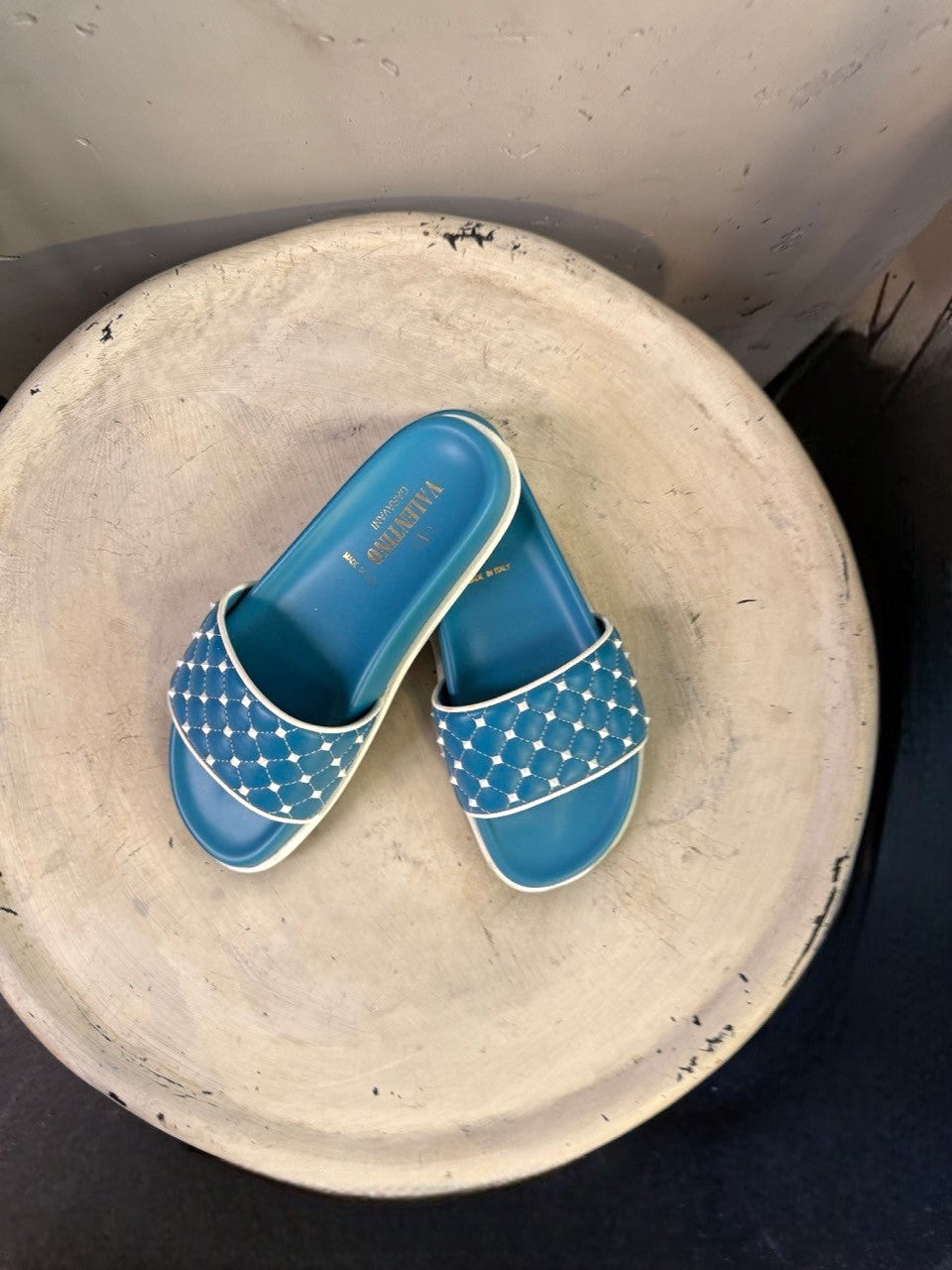 BERLIN VINTAGE CORNER teal slide sandals with white trim and studded quilted straps. Comfortable, stylish, and perfect for warm weather.