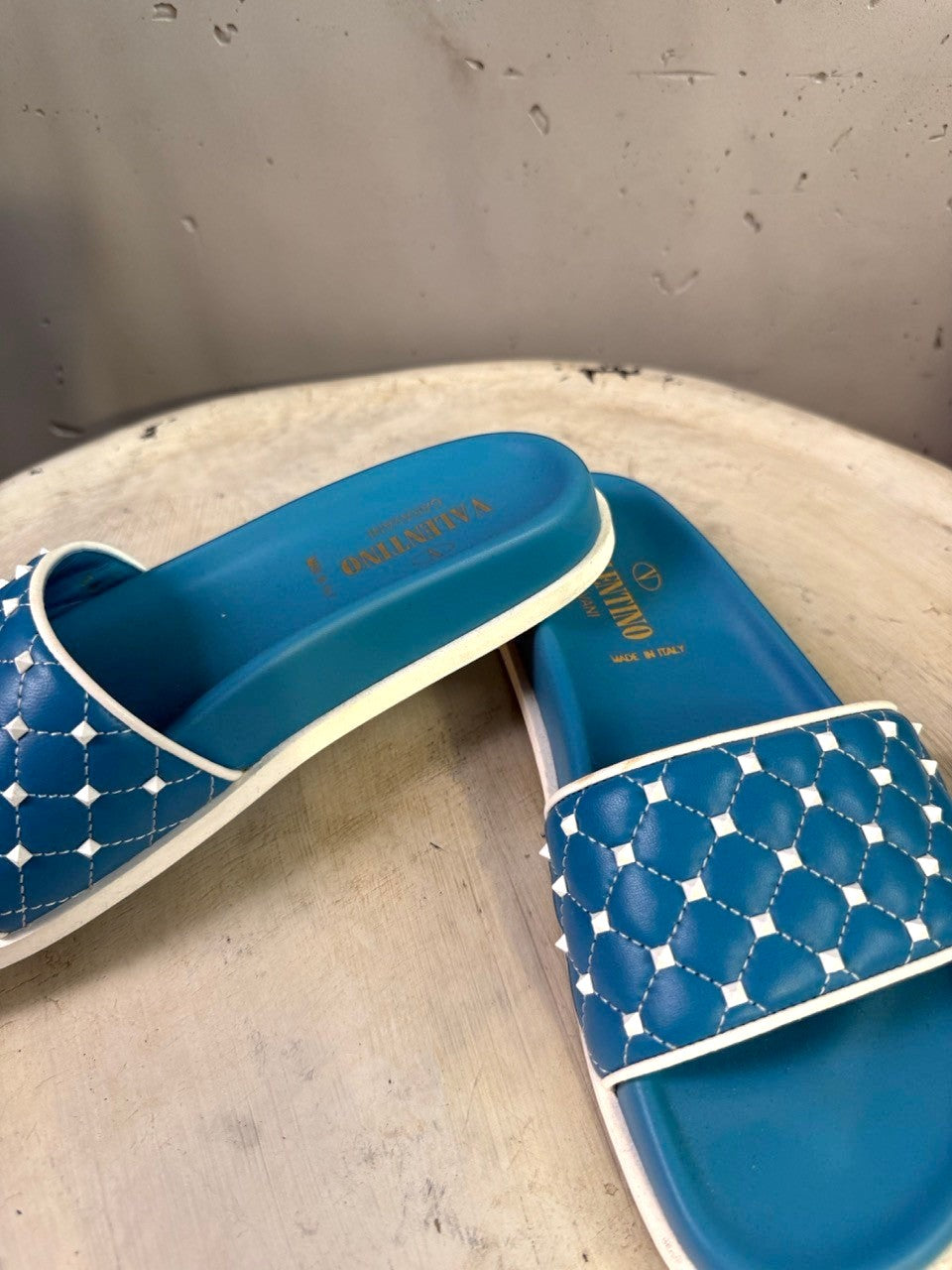 BERLIN VINTAGE CORNER teal slide sandals with white trim and studded quilted straps.