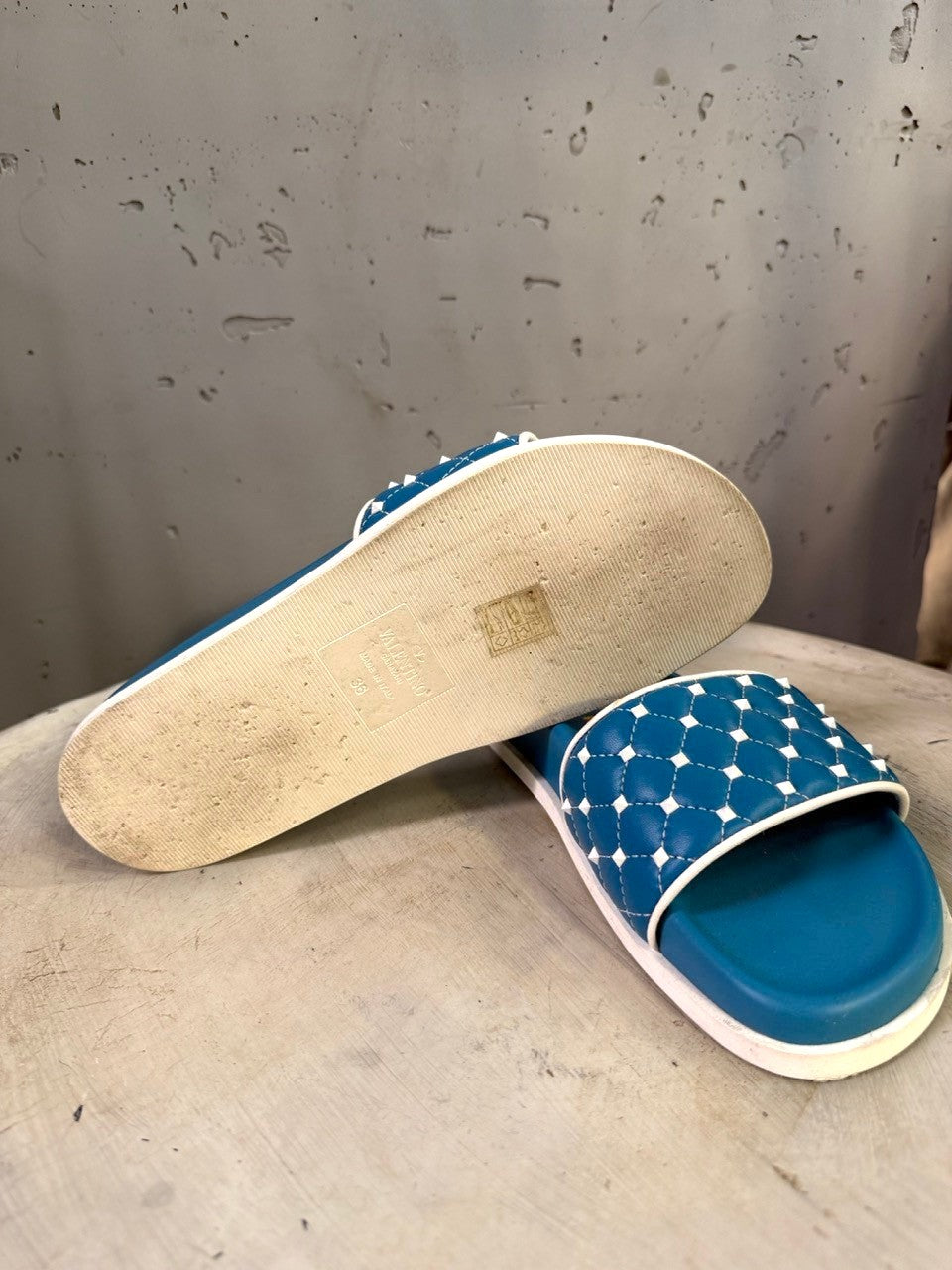 BERLIN VINTAGE CORNER teal slide sandals with white trim and quilted strap adorned with studs.