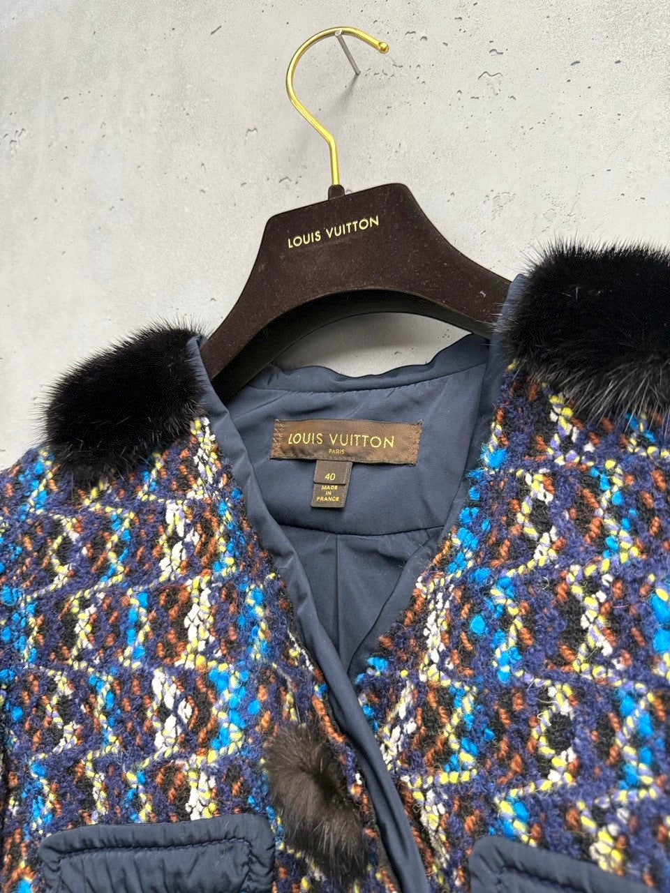 BERLIN VINTAGE CORNER textured tweed cropped jacket with blue, brown, and yellow pattern, black fur collar, and fur pom-poms.