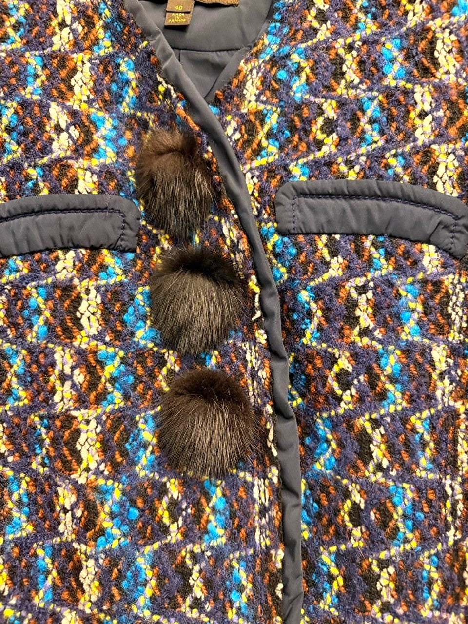 BERLIN VINTAGE CORNER textured tweed cropped jacket with blue, brown, yellow, and black pattern, featuring black fur accents and pom-poms.