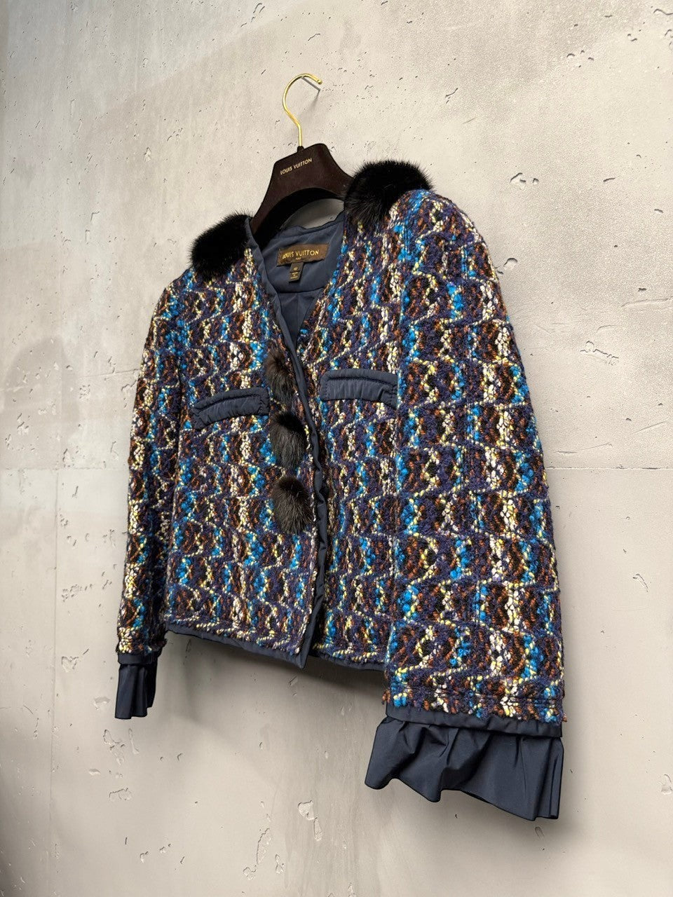 BERLIN VINTAGE CORNER textured tweed cropped jacket with blue, brown, yellow, and black tones, black fur collar, and pom-poms.