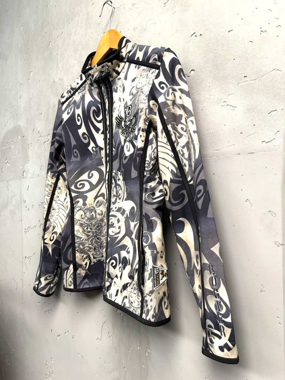 BERLIN VINTAGE CORNER grey, black, and cream tribal print zip-up jacket with stand-up collar and embroidered chest detail.