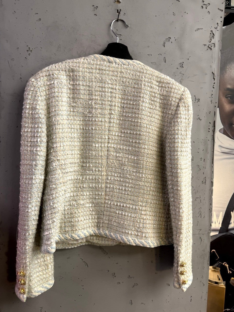 BERLIN VINTAGE CORNER light tweed blazer with metallic threading and gold-tone cuff buttons on a hanger.