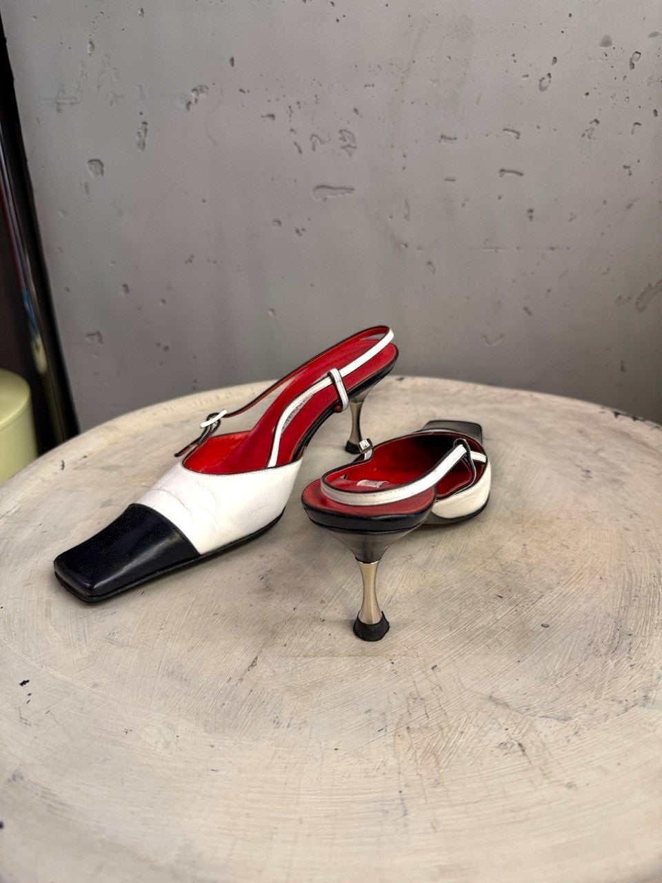 BERLIN VINTAGE CORNER two-tone leather slingback heels with black toe, white upper, red lining, and metallic heel.