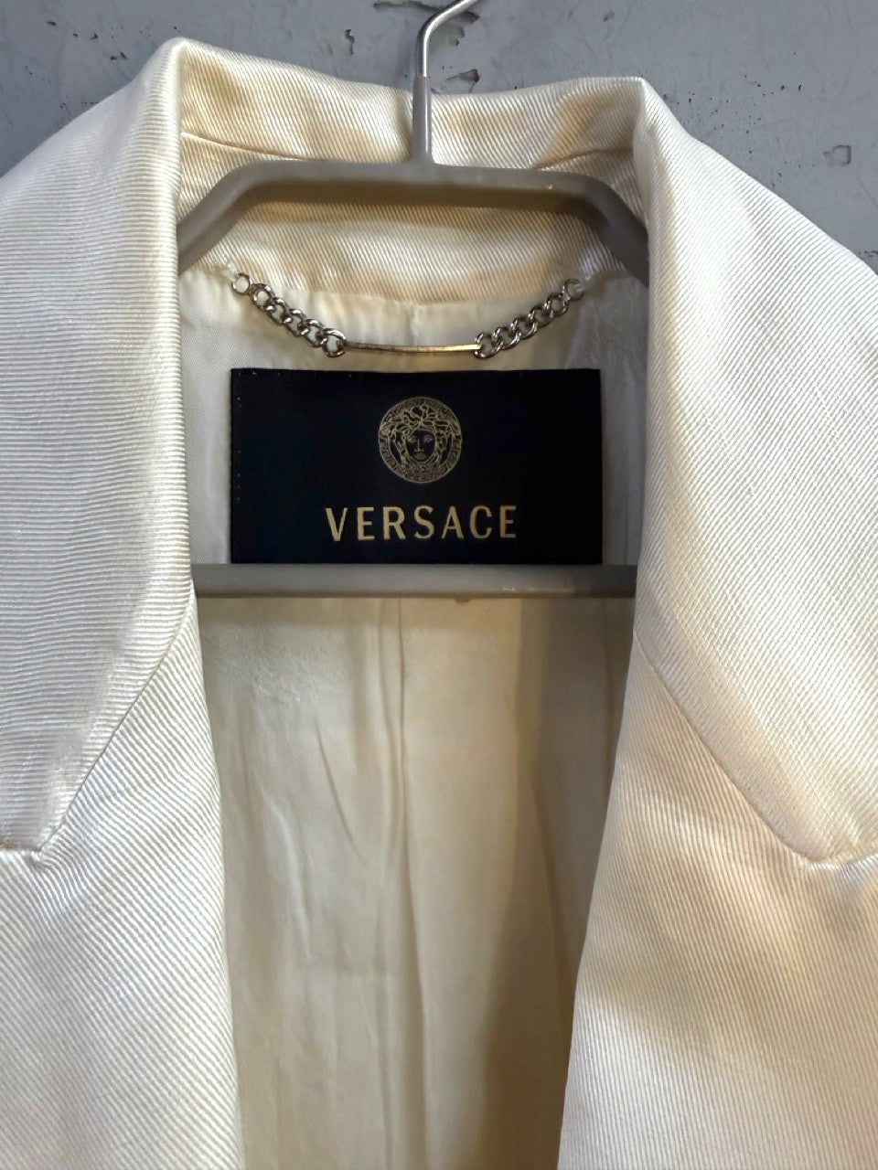 BERLIN VINTAGE CORNER Versace woven label with gold Medusa head at the neck.
