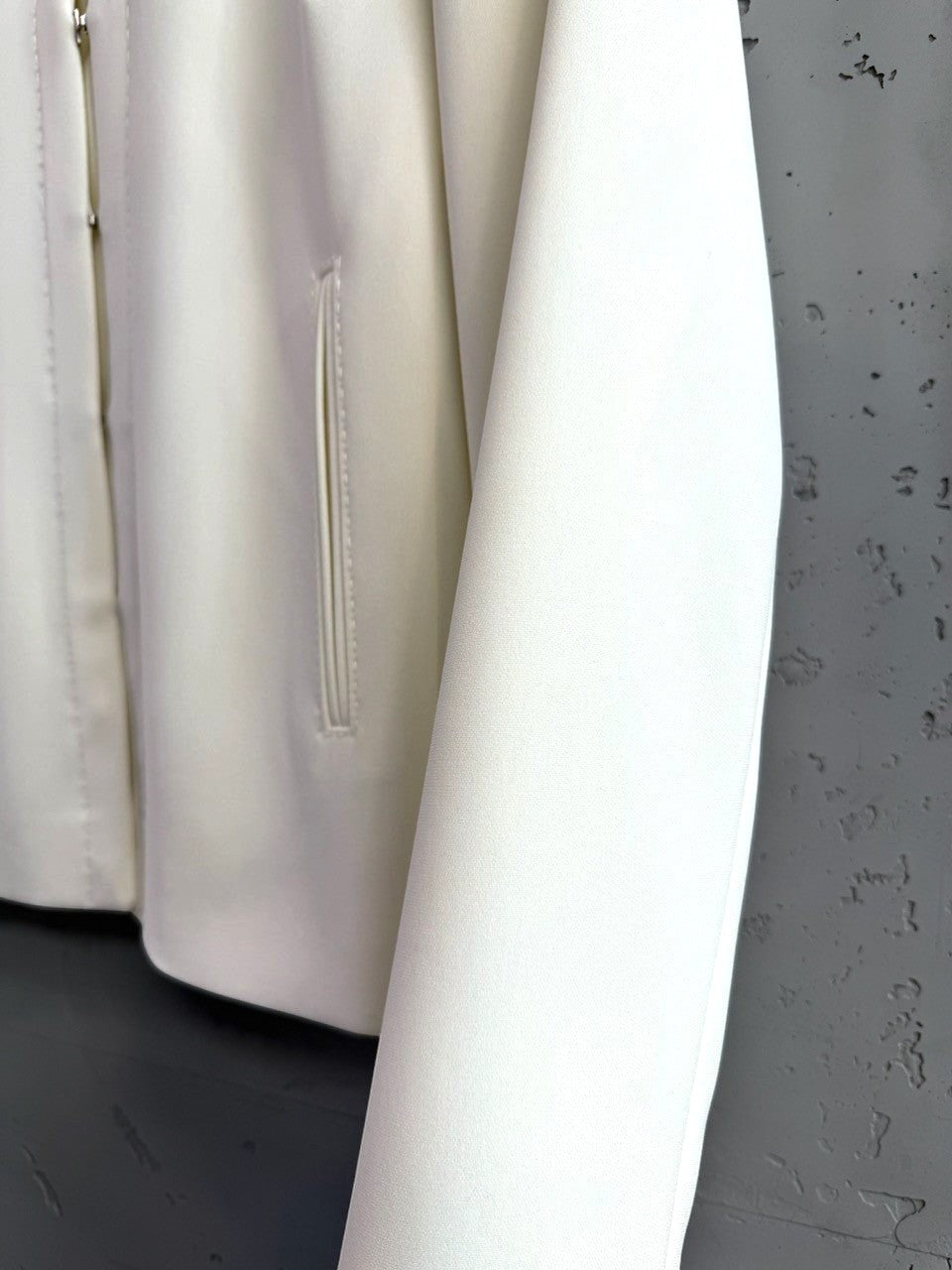 BERLIN VINTAGE CORNER white cropped jacket with piped pocket and zipper closure. Smooth structured fabric.