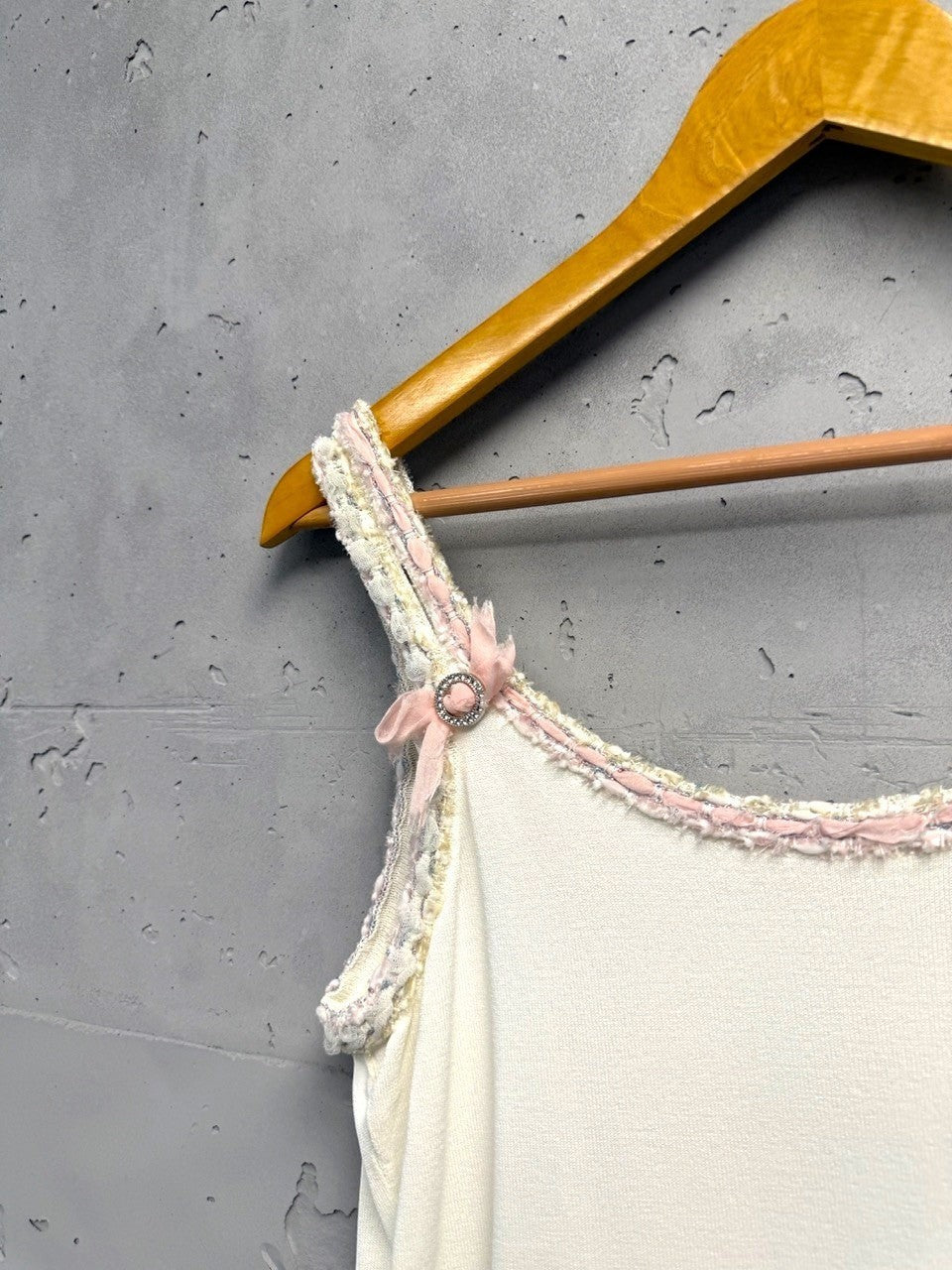 BERLIN VINTAGE CORNER white knit camisole with pink bow embellished spaghetti straps and braided trim.