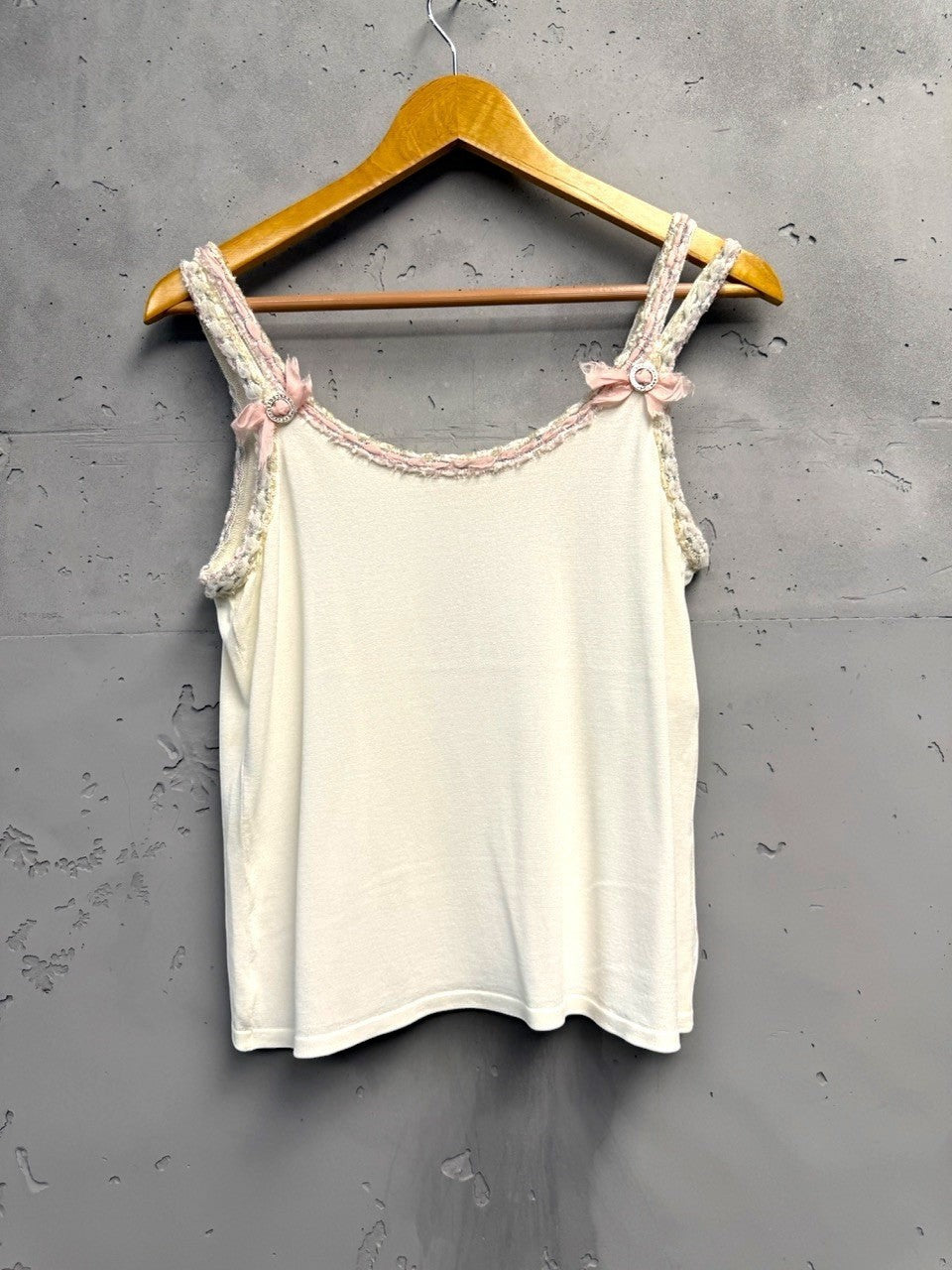 BERLIN VINTAGE CORNER white knit camisole with pink bow and rhinestone embellished spaghetti straps and braided trim.
