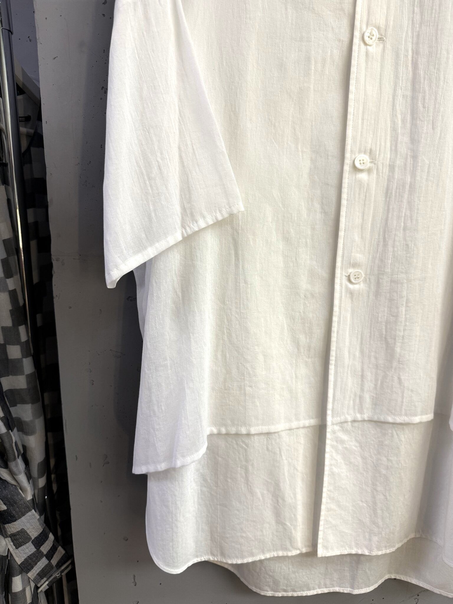 BERLIN VINTAGE CORNER white oversized cotton button-down shirt with a unique layered hem and drop-shoulder design.