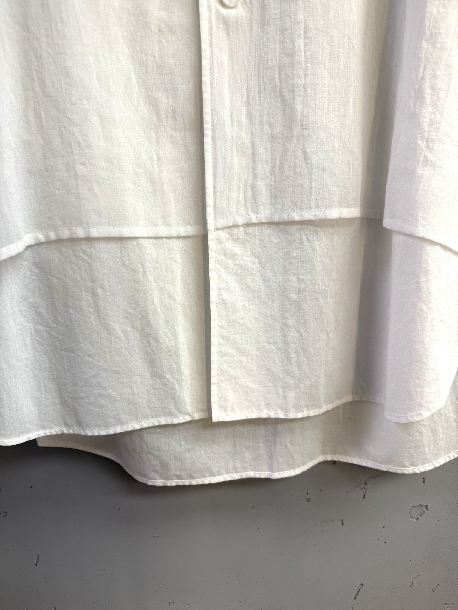BERLIN VINTAGE CORNER white cotton button down shirt featuring a unique layered hem design and crisp fabric texture.
