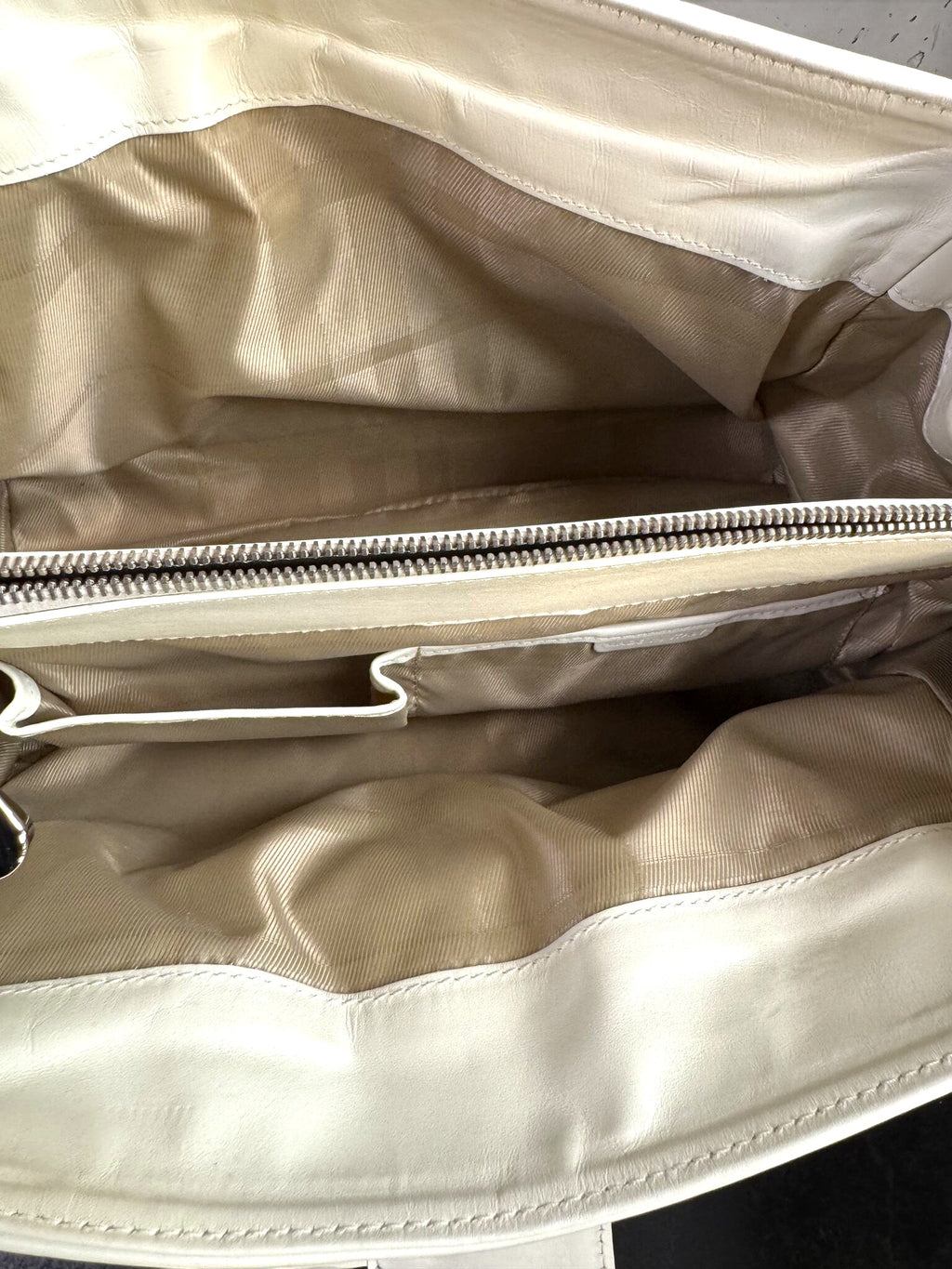 Interior of a BERLIN VINTAGE CORNER white leather handbag featuring a fabric lining, zipper pocket, and slip pockets.