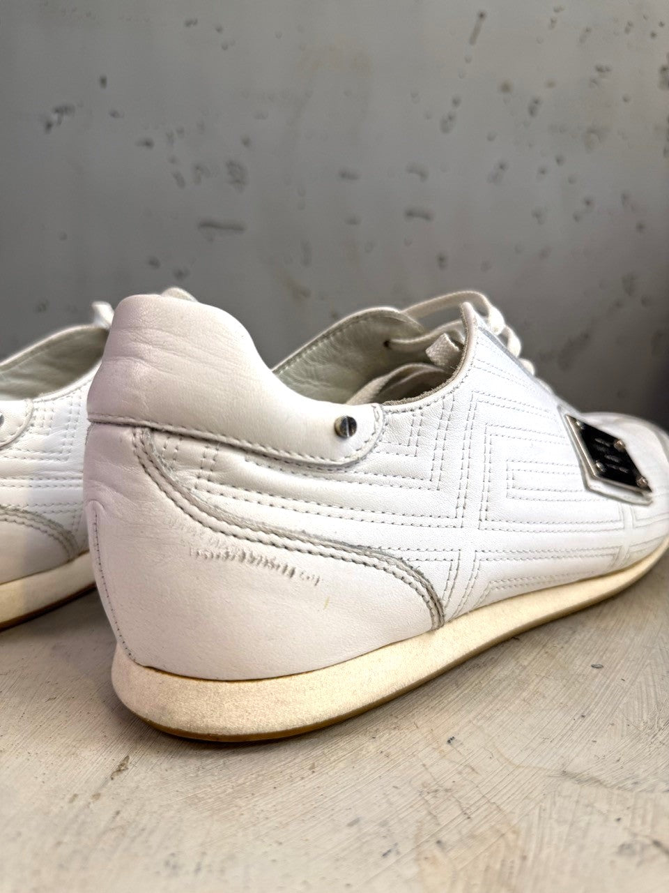 BERLIN VINTAGE CORNER white leather low top sneakers with embossed geometric pattern and metal accent.