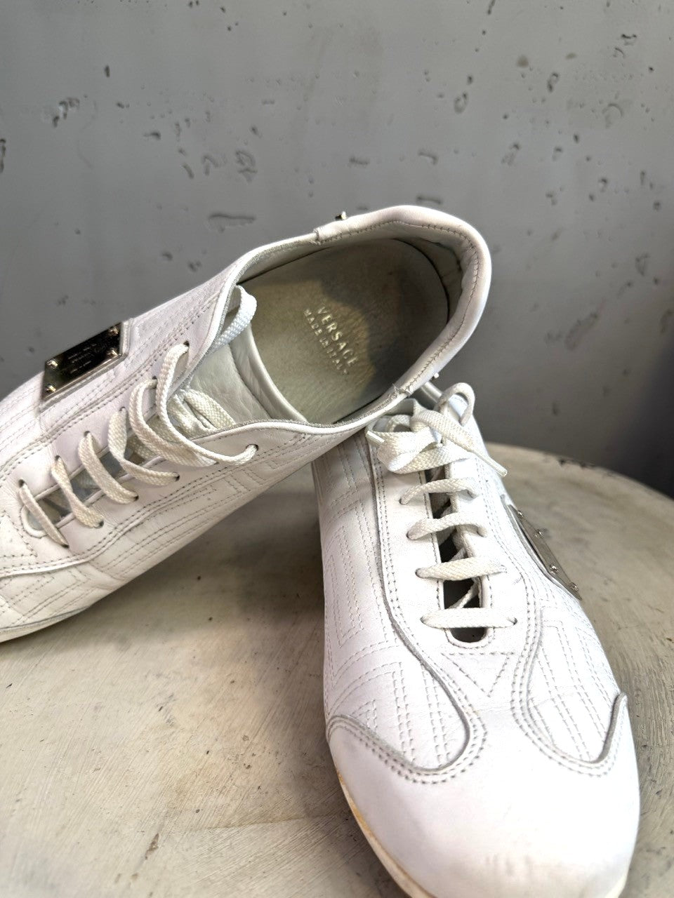 BERLIN VINTAGE CORNER white leather low top sneakers with lace-up closure and metal accent.