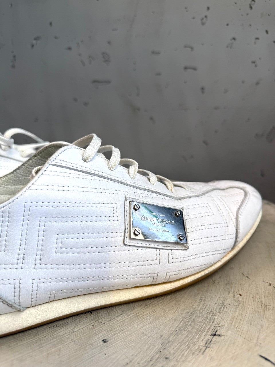 BERLIN VINTAGE CORNER white leather low top sneakers with Greek key pattern and metal accent.