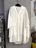 BERLIN VINTAGE CORNER white oversized cotton button-down shirt with a notched collar and layered hem detail.