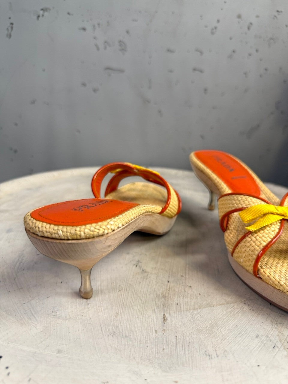 BERLIN VINTAGE CORNER woven raffia slide heeled sandals with orange leather trim and yellow bow accent.