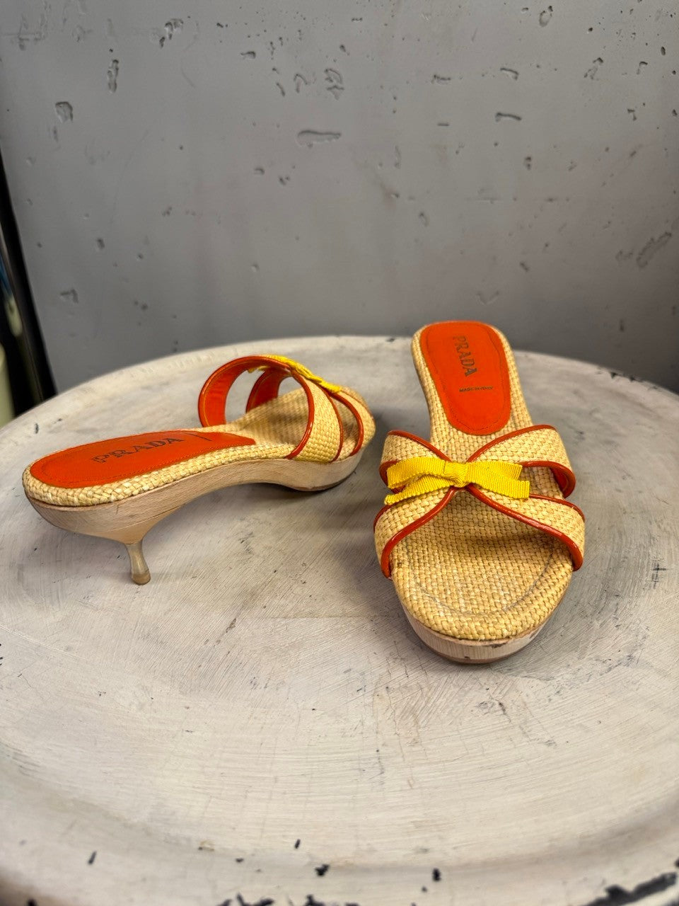 BERLIN VINTAGE CORNER woven raffia slide heeled sandals with orange trim, yellow bow accent, and wooden heel.