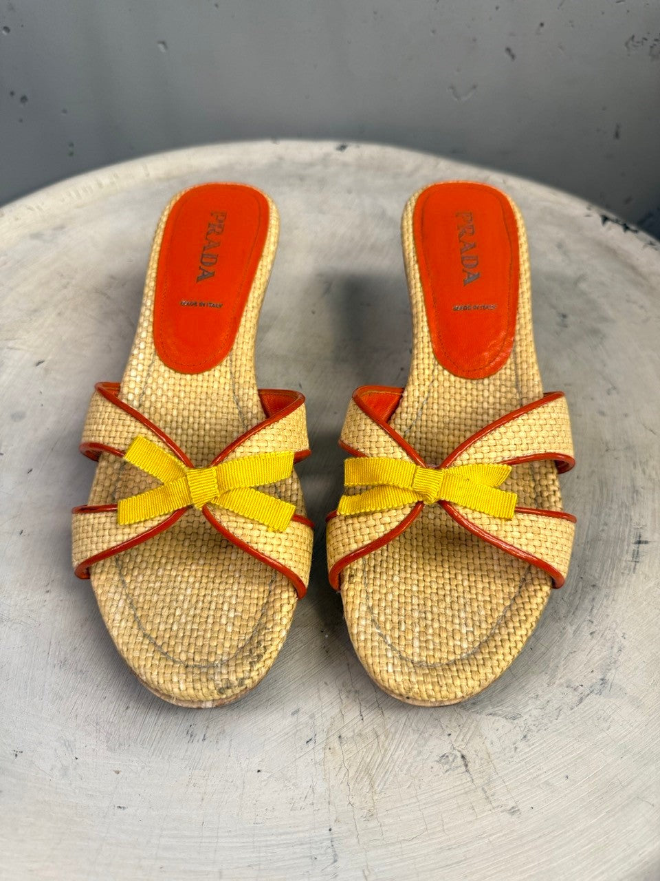 BERLIN VINTAGE CORNER woven raffia slide sandals with orange leather trim and insole, featuring a yellow ribbon bow accent.