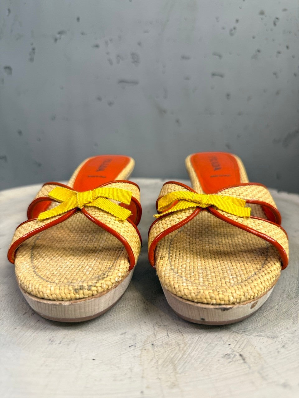 BERLIN VINTAGE CORNER woven raffia slide heeled sandals with orange trim, yellow bow accent, and wooden platform heel.