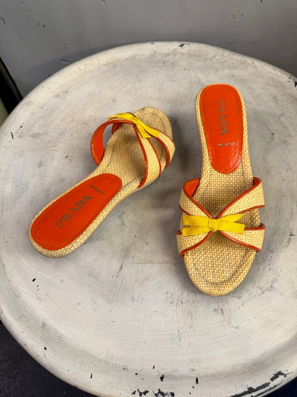 BERLIN VINTAGE CORNER natural woven raffia slide sandals with orange trim, yellow bow accent, and orange leather insole.
