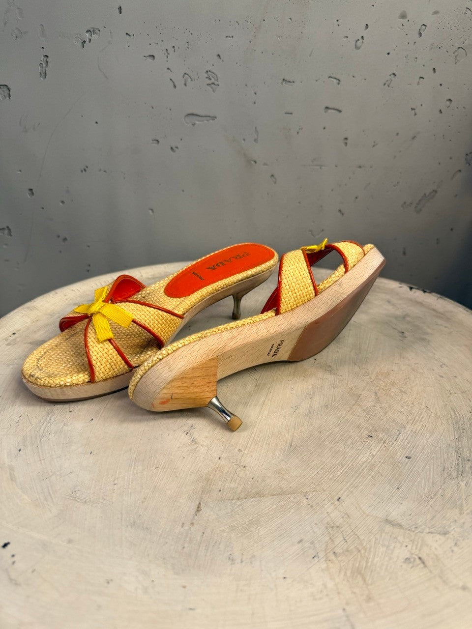 BERLIN VINTAGE CORNER woven raffia slide sandals with red trim, yellow bow accent, wooden heel and metallic stiletto.